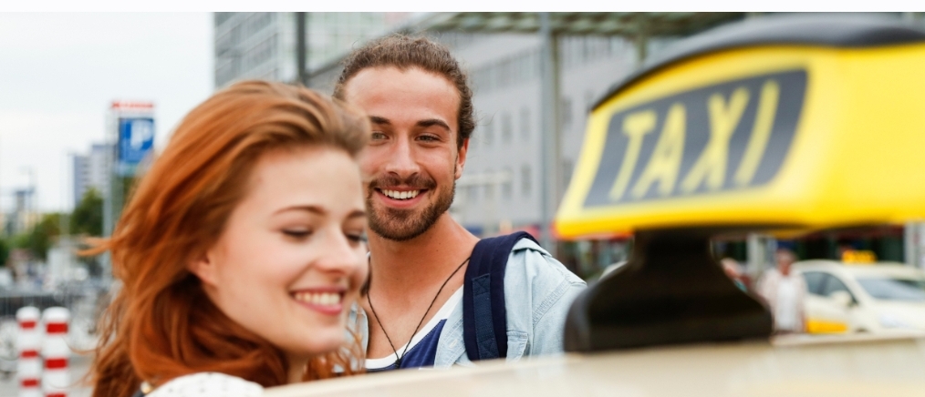 Passageiros felizes ao lado de um táxi em Luxemburgo